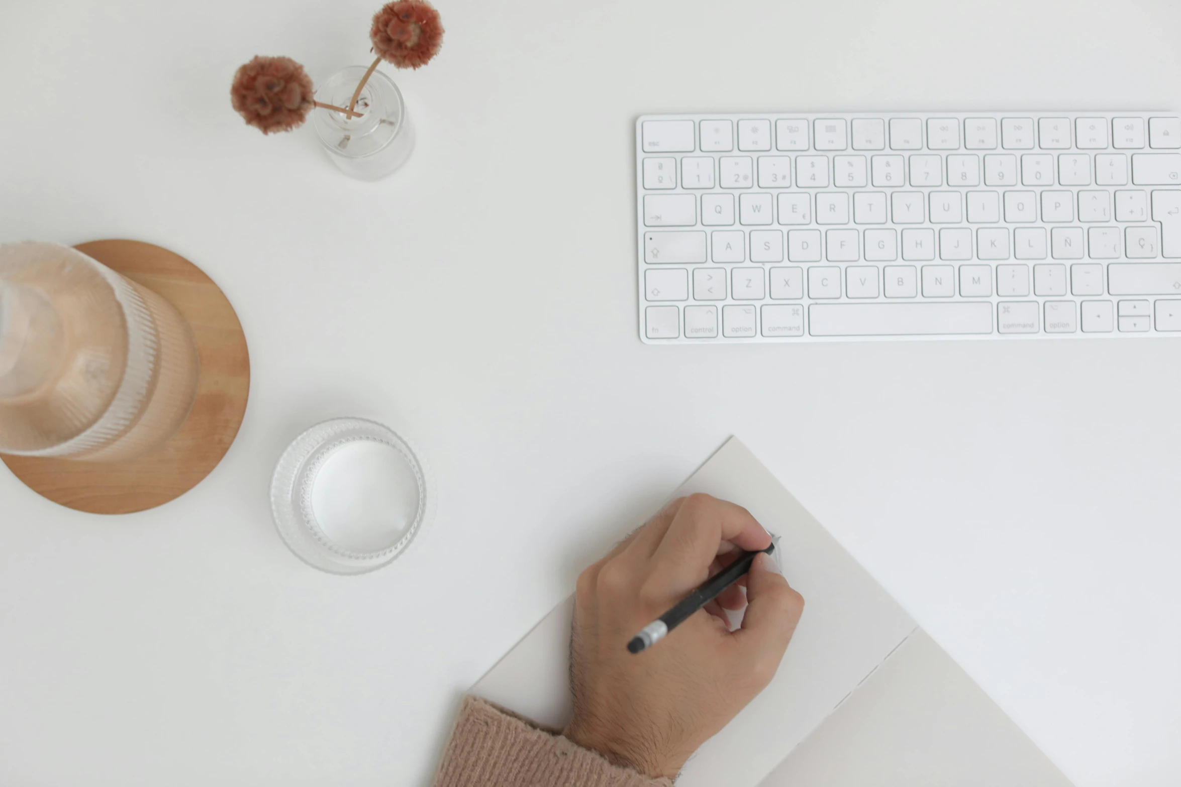 a person writing on a piece of paper next to a keyboard and a cup of coffee, trending on pexels, white background : 3, sitting in an empty white room, background image, 9 9 designs