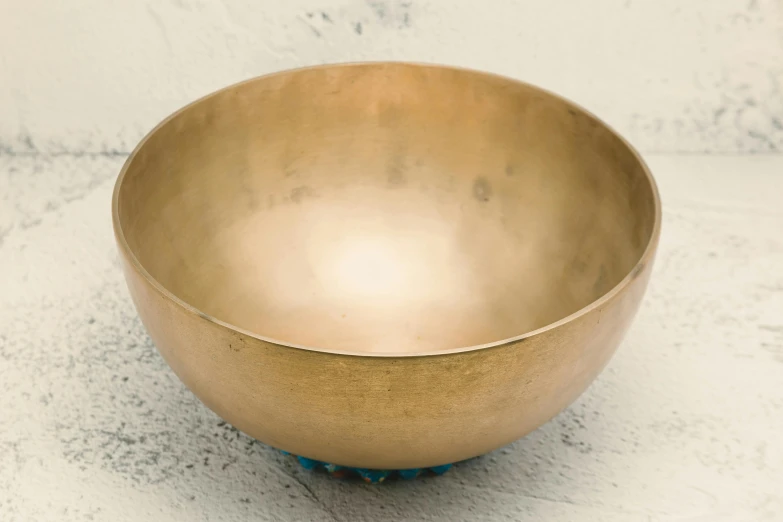 a golden bowl sitting on top of a table, an album cover, unsplash, turquoise, meditation, britain, fine texture detail