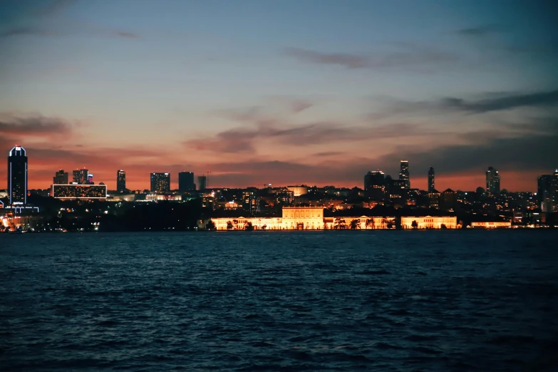 a large body of water with a city in the background, an album cover, pexels contest winner, hurufiyya, humid evening, istanbul, view from the sea, biennale