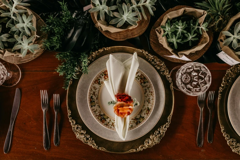 a wooden table topped with plates and silverware, on a plate