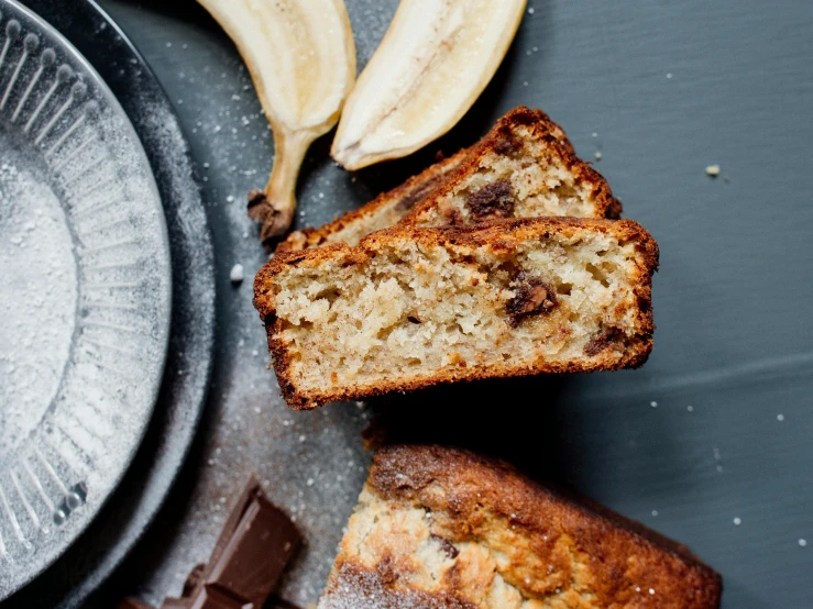 a loaf of banana bread with a bite taken out of it, a still life, by Sylvia Wishart, trending on pexels, square, chocolate, grey, panels