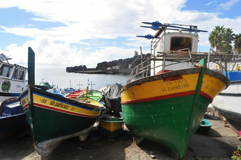 a number of boats on a beach near a body of water, a picture, azores, fishing village, youtube thumbnail, portrait photo