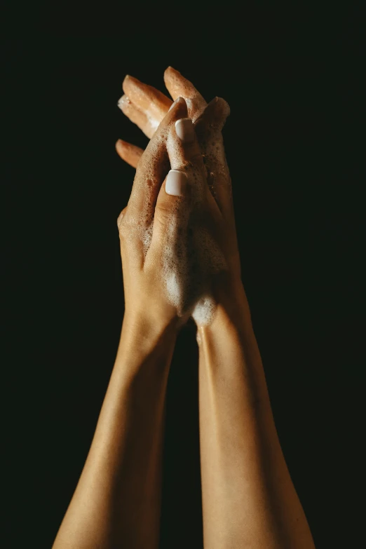 a person washing their hands with soap, by Nina Hamnett, on black background, square, prayer hands, waxy skin