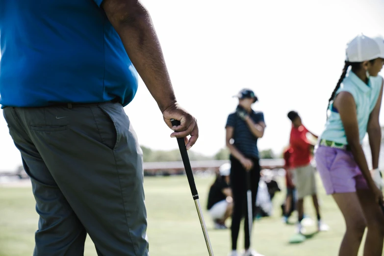 a group of people playing a game of golf, a portrait, by Joe Bowler, pexels contest winner, a person standing in front of a, profile image, holding a thick staff, promo image