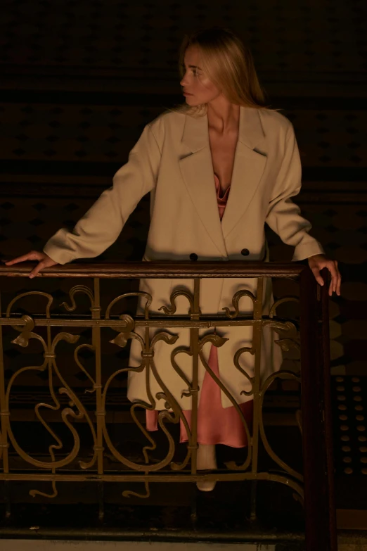 a woman standing on a balcony at night, inspired by Vanessa Beecroft, trending on pexels, renaissance, light brown coat, ( ( theatrical ) ), hollywood promotional image, detail shot