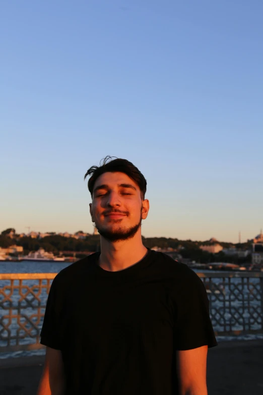 a man standing in front of a body of water, reddit, hurufiyya, headshot profile picture, elias chatzoudis, in the evening, profile image