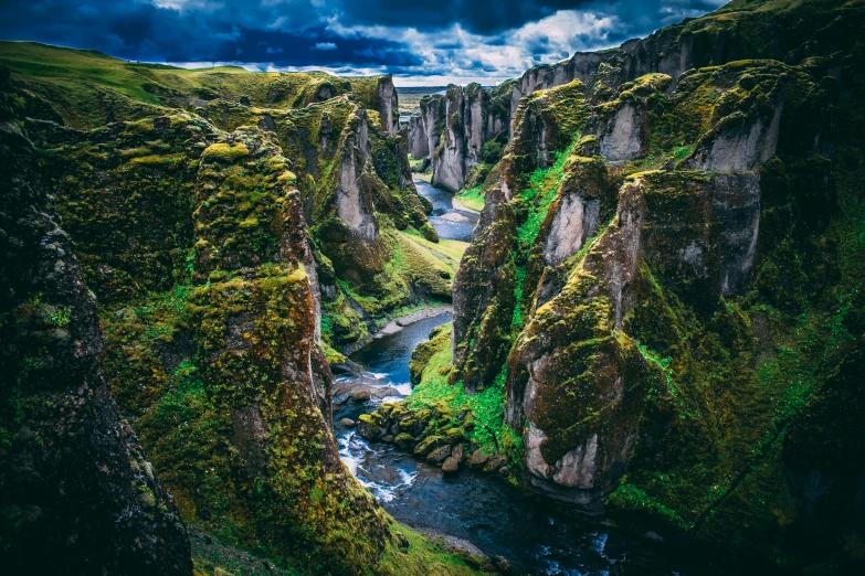 a river flowing through a lush green valley, by Tom Wänerstrand, pexels contest winner, renaissance, tall stone spires, deep chasm, with jagged rocks & eerie, post processed