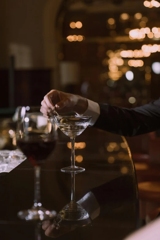 a man in a tuxedo pours a glass of wine, inspired by Carlo Martini, inside a grand, detailed cinematic shot, nightcap, ignant