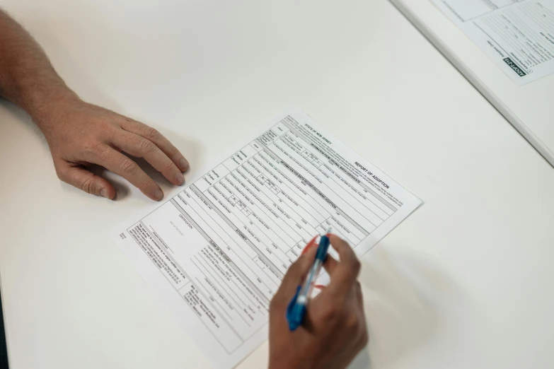 a person sitting at a table with a pen and paper, on a white table, official documentation, thumbnail, background image