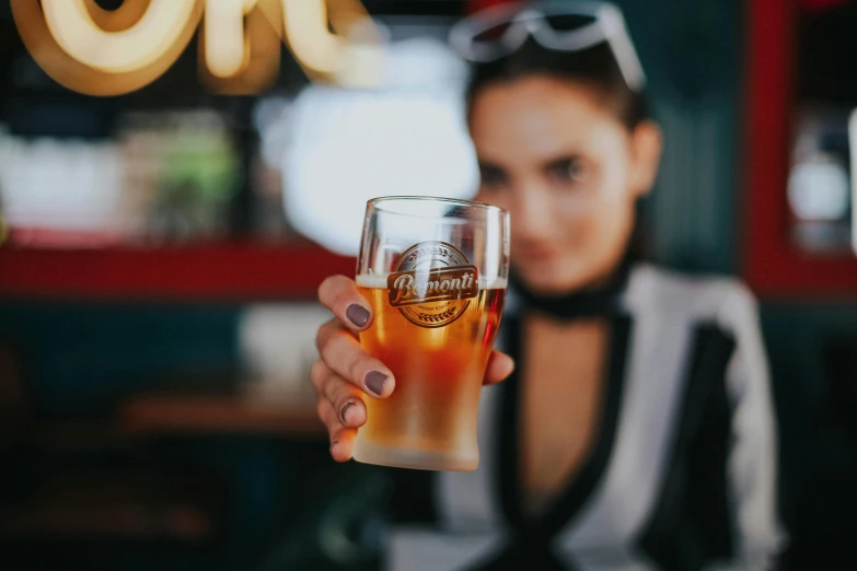 a woman holding up a glass of beer, aussie baristas, premium quality, fan favorite, instagram post