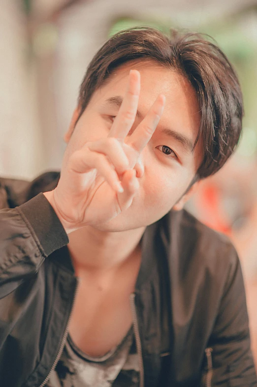 a man making a peace sign with his fingers, inspired by Adam Dario Keel, pexels contest winner, young cute wan asian face, discord profile picture, kpop, grainy