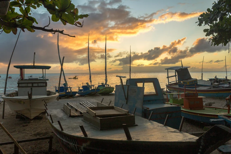 a group of boats sitting on top of a sandy beach, during a sunset, fishing village, amanda lilleston, multiple stories