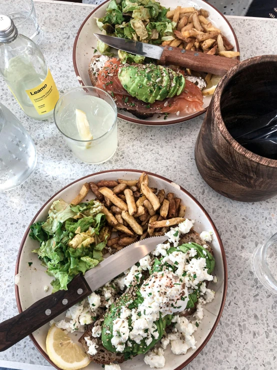 a table topped with two plates of food, instagram, happening, avacado dream, no filter, with fries, whistler