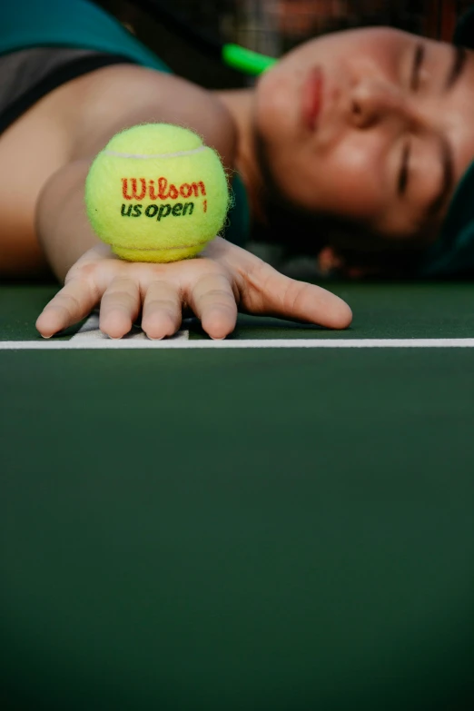 a woman holding a tennis ball on top of a tennis court, by Winona Nelson, lying down, wenjun lin, close - up on face, ap press photo