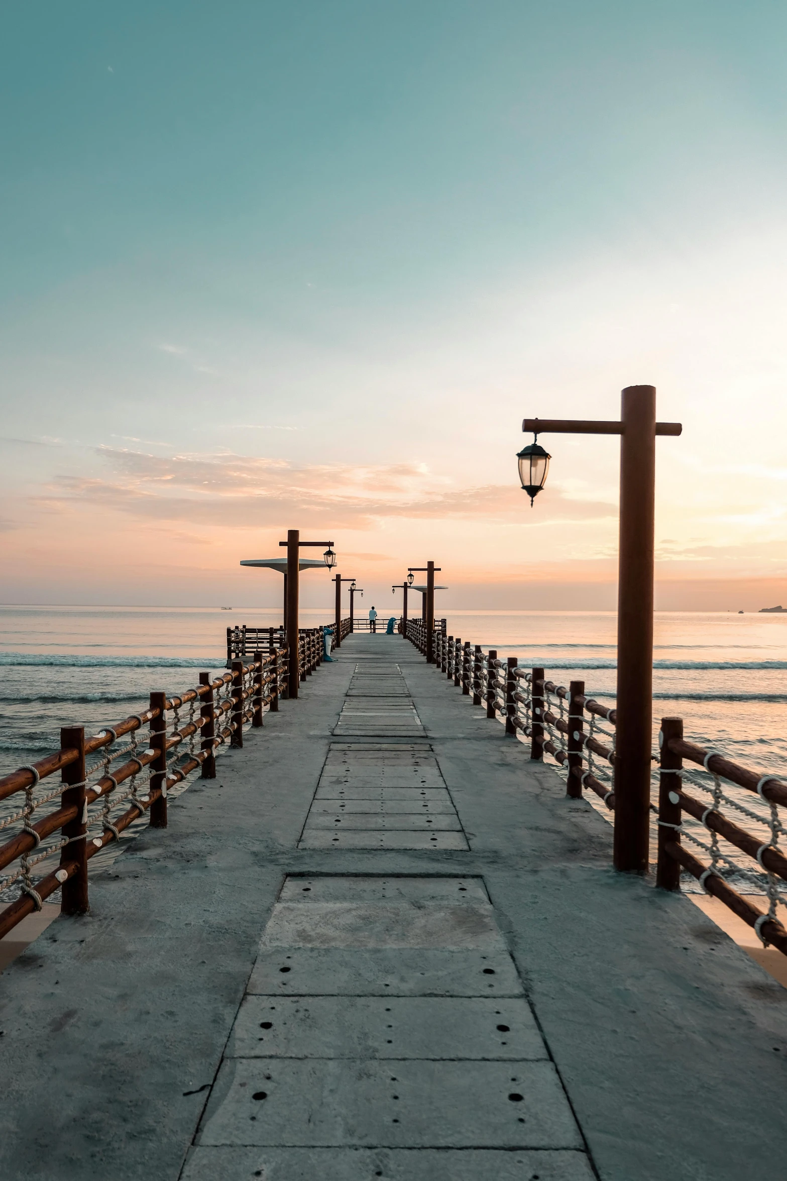 a pier that is next to the ocean, during a sunset, walking down, peru, visually crisp & clear