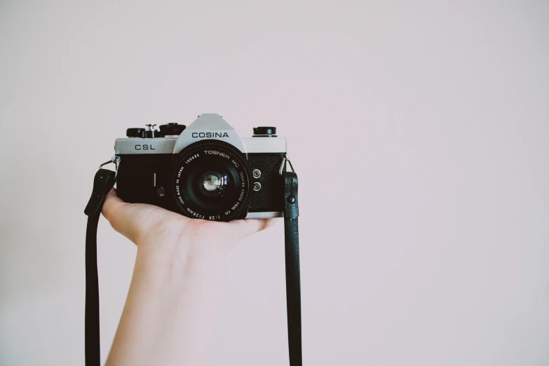 a person holding a camera in their hand, a picture, by Carey Morris, unsplash, on a pale background, canon a 1, photograph”