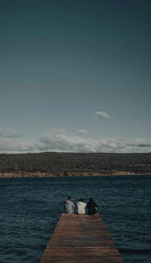 two people sitting on a dock next to a body of water, by Thomas Furlong, unsplash, minimalism, they are chasing a whale, two aboriginal elders, dingy, high quality photo