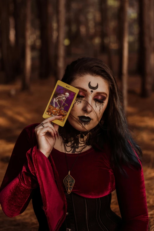 a woman in a red dress holding a card in front of her face, a polaroid photo, pexels contest winner, renaissance, tiefling female warlock, professional cosplay, moon goddess, /!\ the sorceress