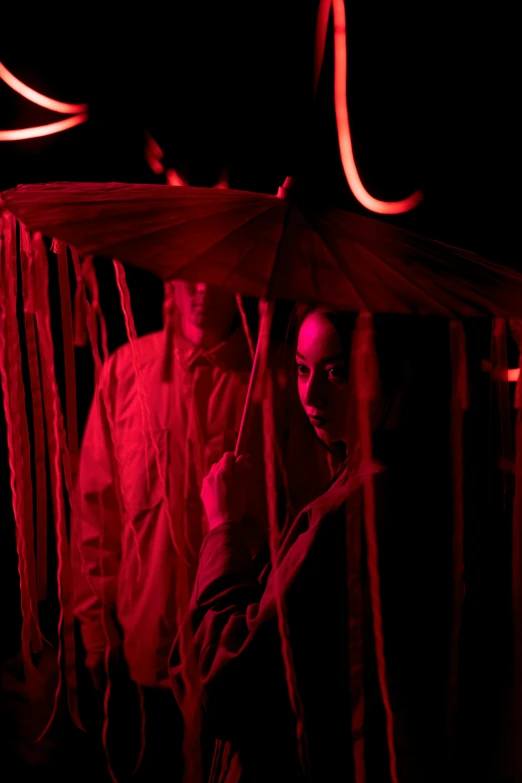 a group of people standing next to each other under an umbrella, detailed red lighting, string puppet, amanda lilleston, couple
