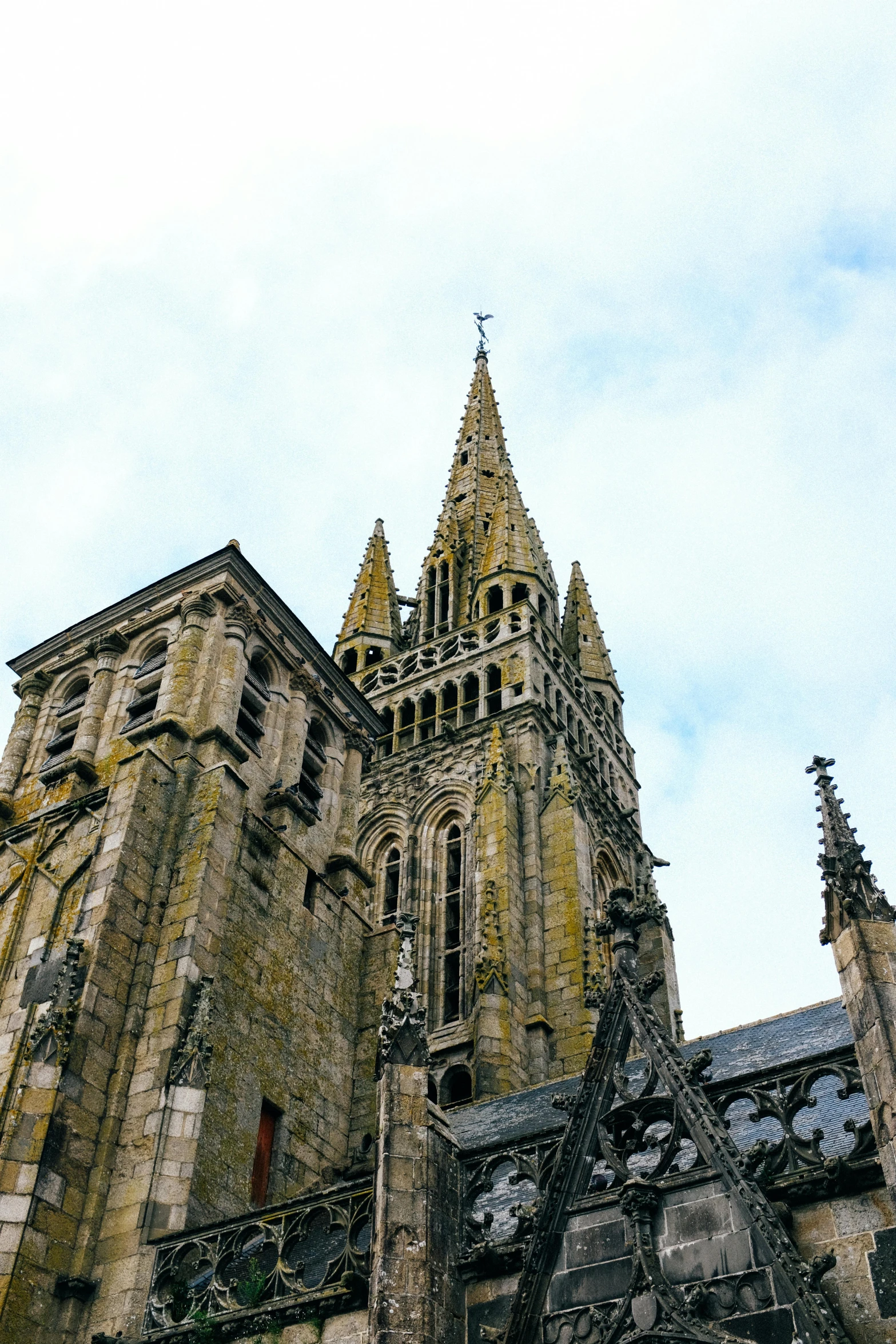 a very tall building with a clock on it's side, inspired by Pierre Toutain-Dorbec, unsplash, romanesque, tall stone spires, normandy, panorama, high - angle view