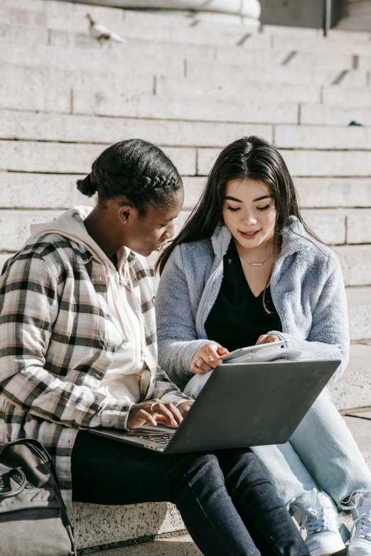 two people sitting on steps looking at a laptop, trending on pexels, renaissance, college girls, mix of ethnicities and genders, teaching, promotional image