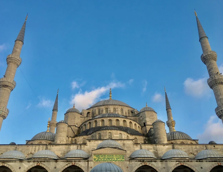 a group of people standing in front of a building, by Ismail Acar, pexels contest winner, hurufiyya, with great domes and arches, blue, 256x256, a wooden