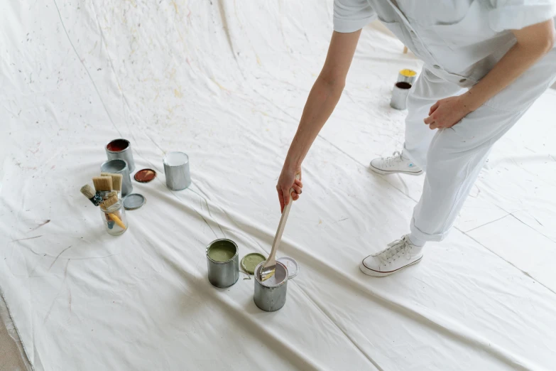 a person that is painting on a white sheet, by Andries Stock, trending on pexels, sustainable materials, grey, white