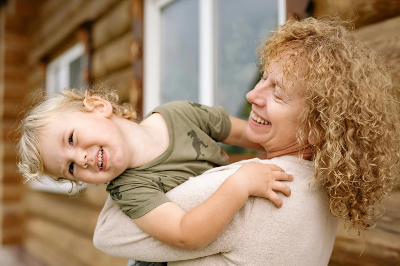 a woman holding a child in her arms, pexels contest winner, curly haired, thumbnail, all overly excited, avatar image