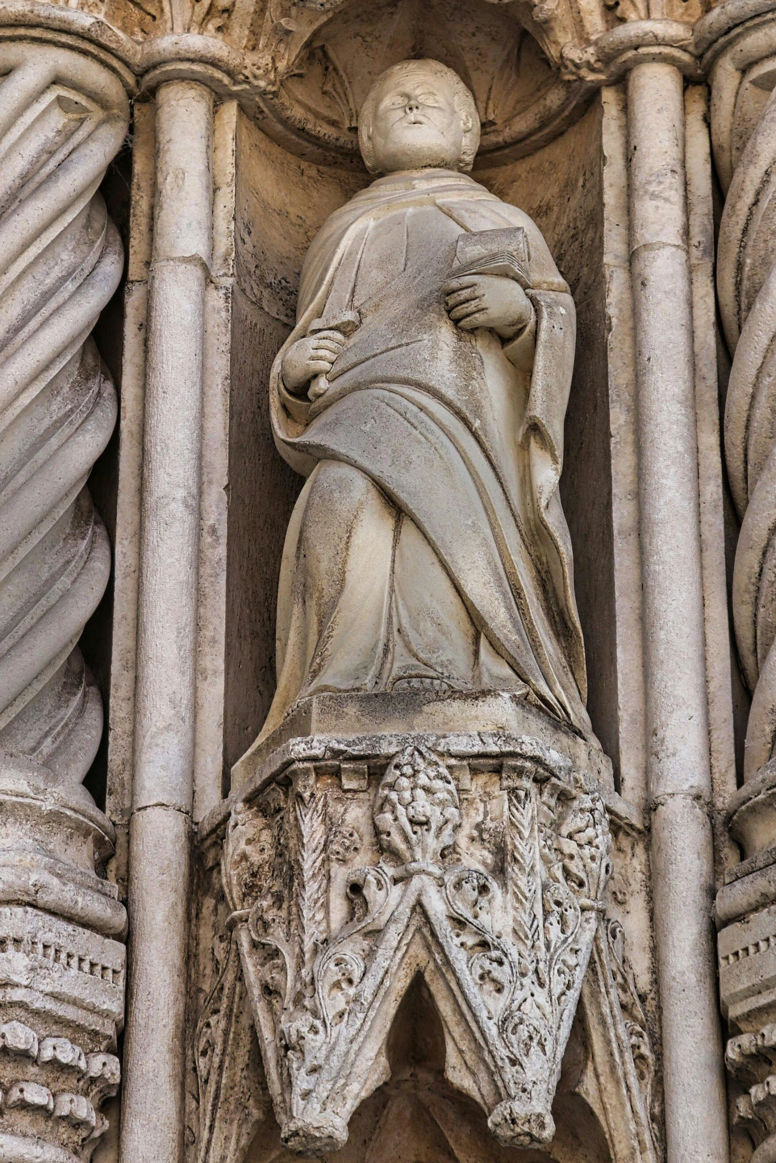 a statue that is on the side of a building, a statue, inspired by Taddeo Gaddi, intricate robes, grey