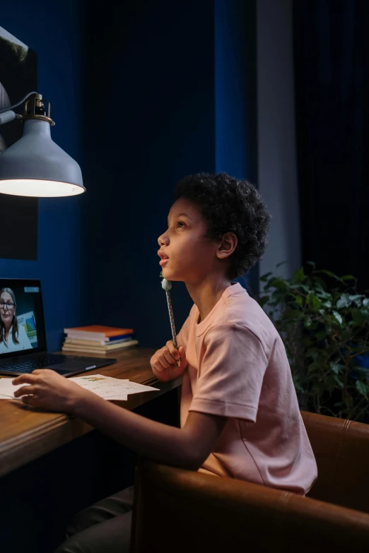 a young boy sitting at a desk in front of a laptop computer, pexels contest winner, hyperrealism, pink and blue lighting, educational, vertical orientation, instagram post