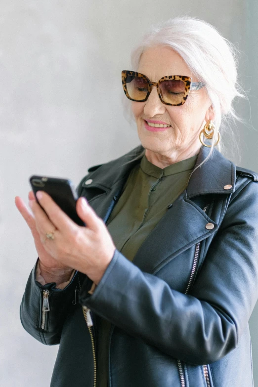 an older woman looking at her cell phone, trending on pexels, wearing leather coat, avatar image, raphael personnaz, rectangle