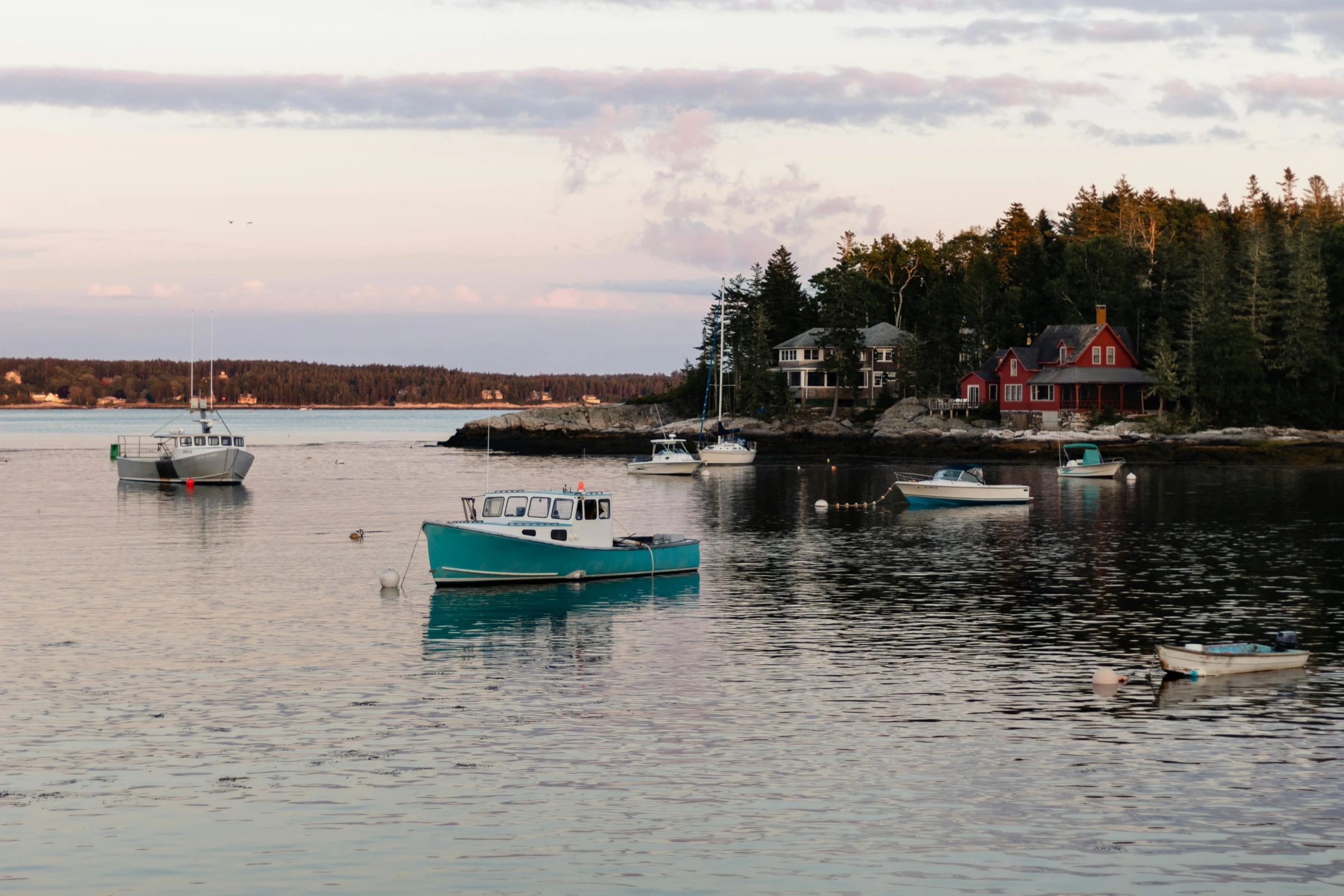 a group of boats floating on top of a body of water, by Jessie Algie, pexels contest winner, new england architecture, glistening seafoam, late summer evening, a quaint