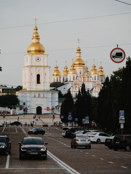 a street filled with lots of traffic next to tall buildings, an album cover, pexels contest winner, socialist realism, ukrainian monk, white and gold color scheme, dome, 000 — википедия