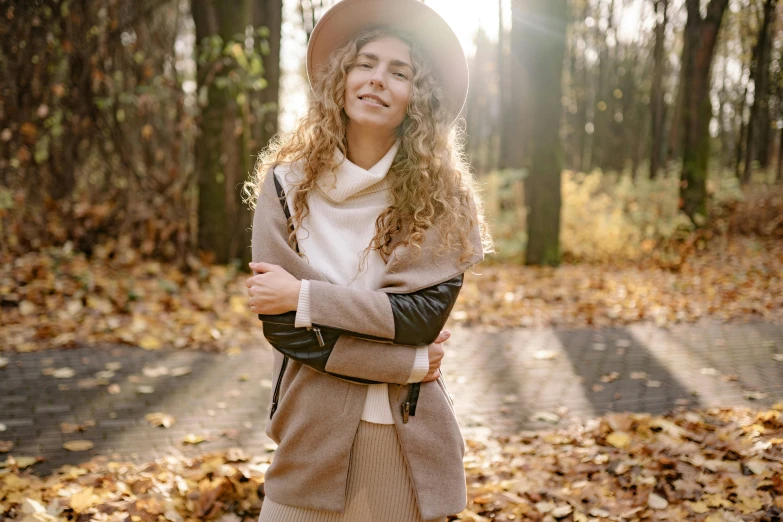 a woman standing in the middle of a forest, a portrait, trending on pexels, straw hat and overcoat, happy fashion model, thumbnail, curly haired