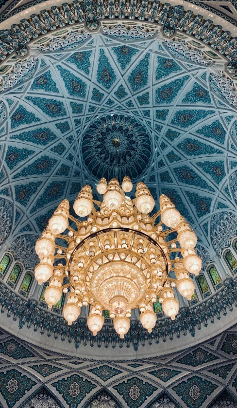 a chandelier hanging from the ceiling of a building, inspired by Abdullah Gërguri, arabesque, cyan and gold scheme, cybermosque interior, 2 5 6 x 2 5 6 pixels, unsplash photo contest winner