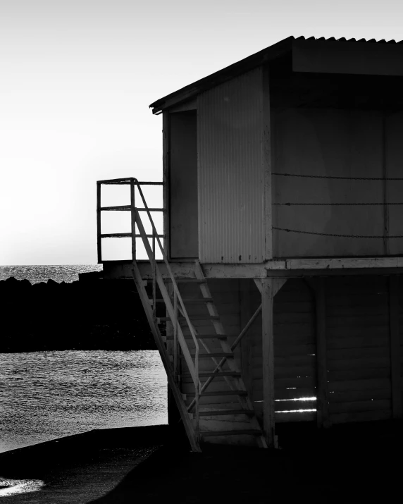 a black and white photo of a lifeguard tower, inspired by Max Dupain, unsplash, postminimalism, square, late summer evening, harbor, white building