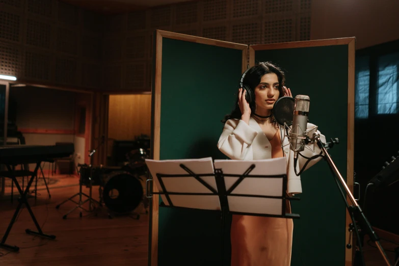a woman that is standing in front of a microphone, an album cover, trending on pexels, hurufiyya, cinematic studio shot, princess jasmine, behind the scenes photo, b - roll
