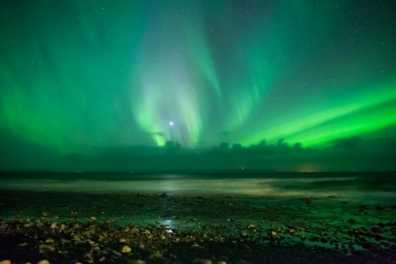 the aurora lights in the sky over a body of water, pexels contest winner, green sea, waves of lights, multiple moons glowing, iceland landscape