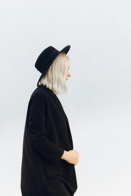 a woman in a black coat and hat, inspired by Louisa Matthíasdóttir, trending on unsplash, minimalism, silver hair so long, profile image, chin-length hair, casual modern clothing