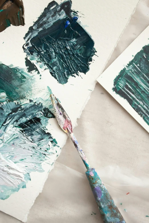 a pair of scissors sitting on top of a piece of paper, an acrylic painting, inspired by Art Green, trending on unsplash, abstract art, thick impasto paint, white and teal metallic accents, model painting, oil on canvas big brushstrokes