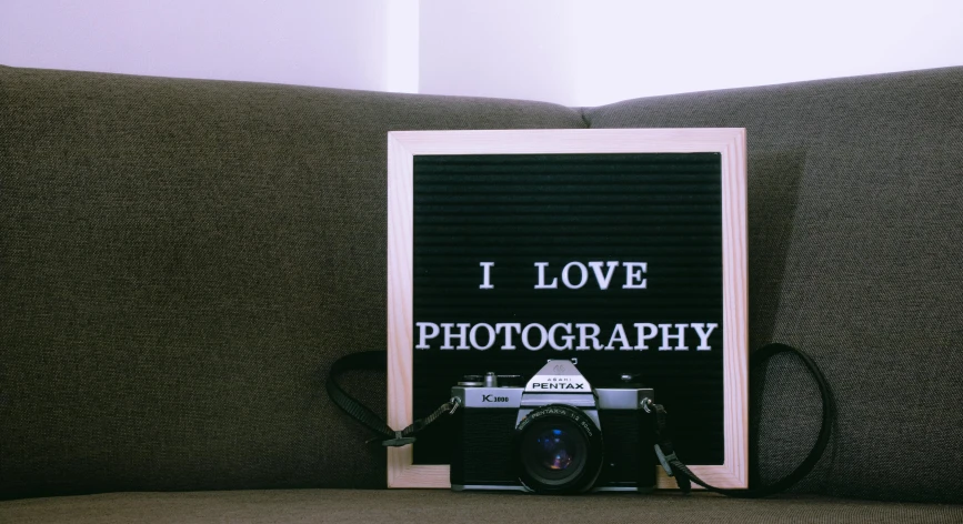 a book sitting on top of a couch next to a camera, on a canva, photograph”, photograph ”, cute photograph