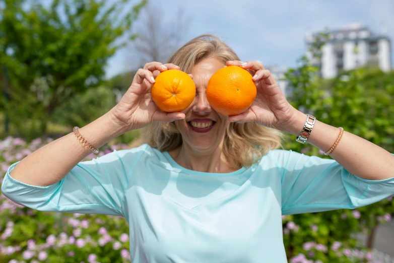 a woman holding two oranges in front of her eyes, a picture, pexels contest winner, happening, cheeky smile, 🦩🪐🐞👩🏻🦳, katinka reinke, avatar image