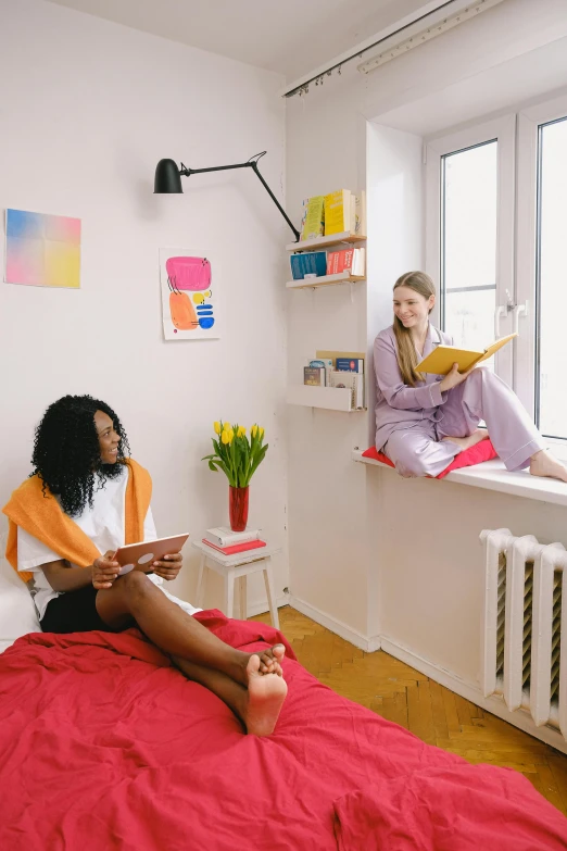 a woman sitting on a bed reading a book, by Zofia Stryjenska, trending on pexels, maximalism, two buddies sitting in a room, bright color scheme, college students, calmly conversing 8k