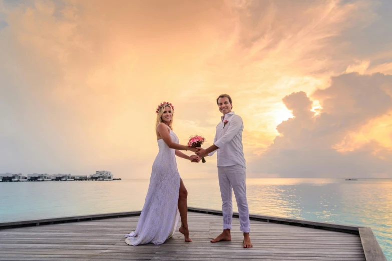 a bride and groom standing on a dock at sunset, inspired by Edwin Georgi, pexels contest winner, maldives in background, full morning sun, flowers around, celebrating