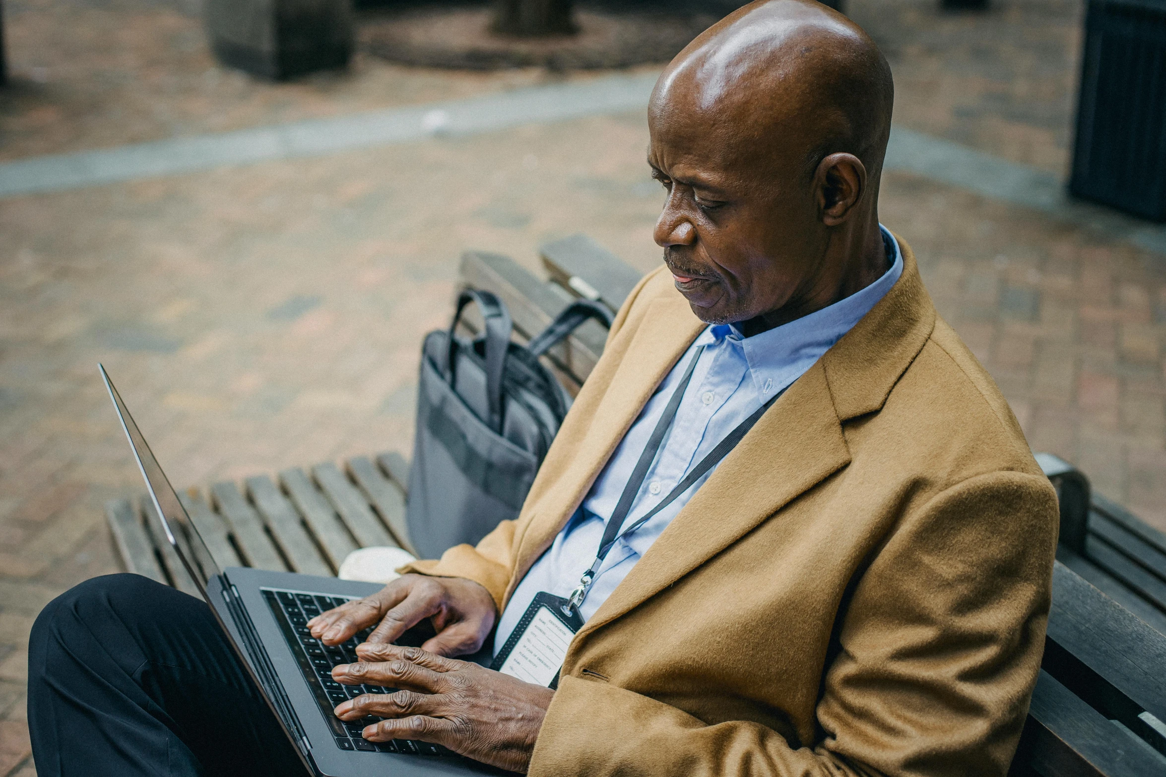 a man sitting on a bench using a laptop computer, by Carey Morris, pexels contest winner, augusta savage, lightly dressed, thumbnail, full frame image