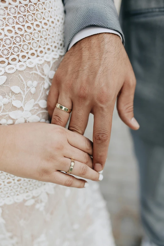 a close up of a person holding a wedding ring, white and gold robes, male and female, lachlan bailey, beige and gold tones