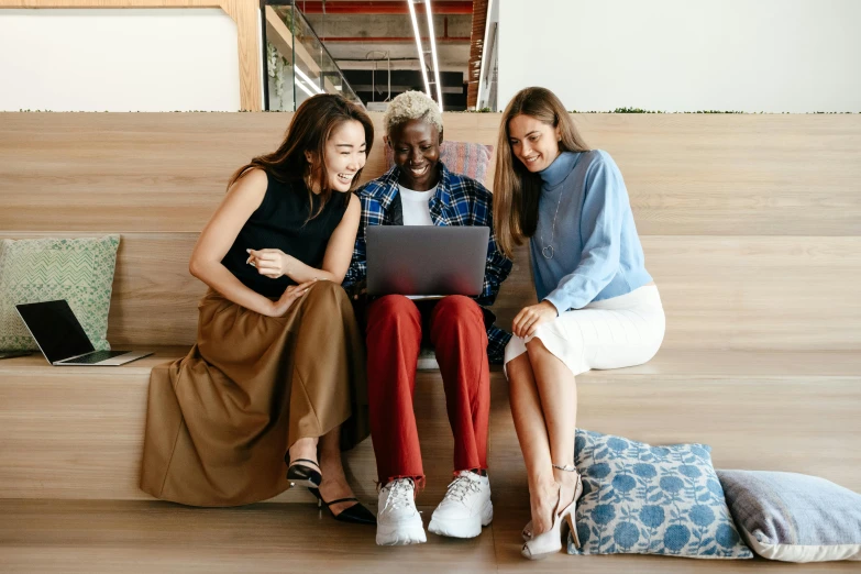 three women sitting on a bench looking at a laptop, trending on pexels, two buddies sitting in a room, avatar image, diverse outfits, awarding winning