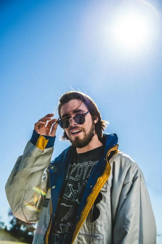 a man standing in a field talking on a cell phone, an album cover, unsplash, graffiti, sun glasses, jacksepticeye, headshot profile picture, hozier