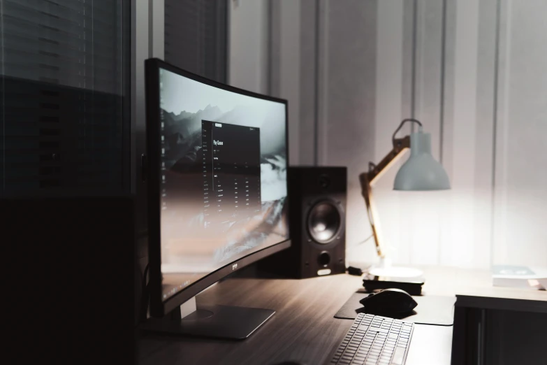 a desktop computer sitting on top of a wooden desk, inspired by Elsa Bleda, grey and dark theme, aesthetic lighting, instagram post, ultrawide