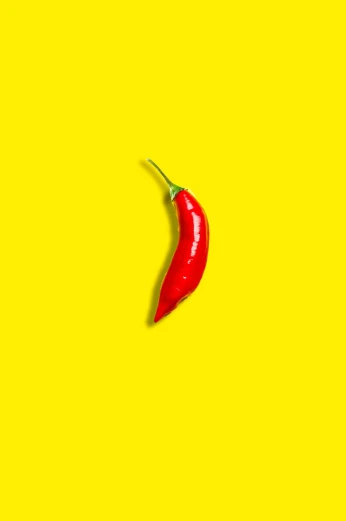 a red chili on a yellow background, a picture, trending on pexels, pop art, ((oversaturated)), pepper, ffffound, high quality upload